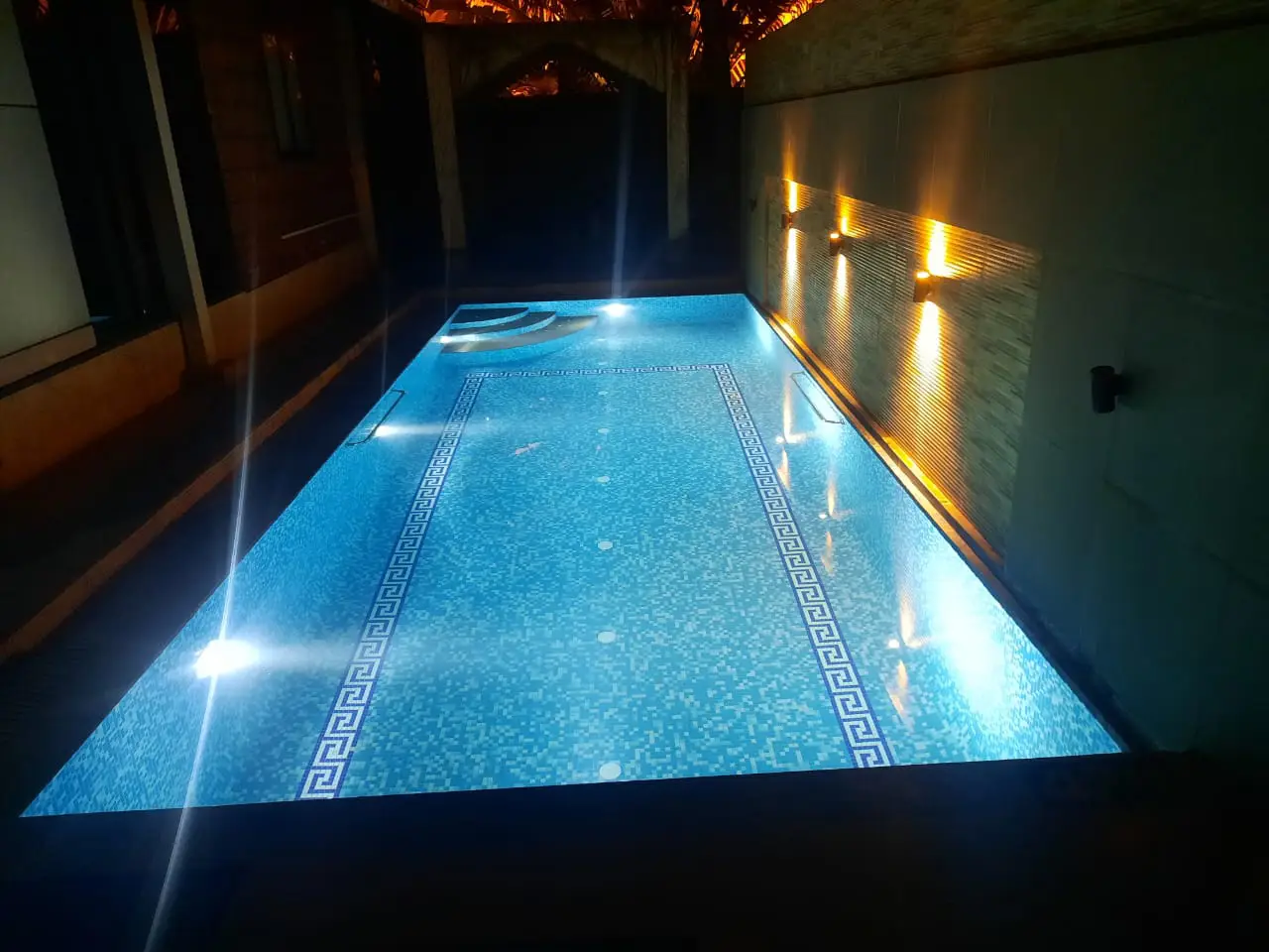 Swimming pool with evening lighting and illuminated water surface