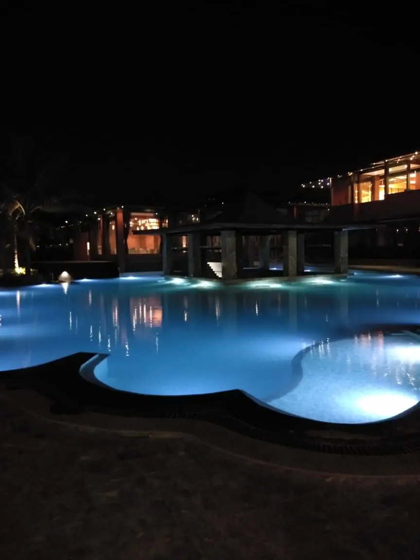 Night view of large resort swimming pool with lighting