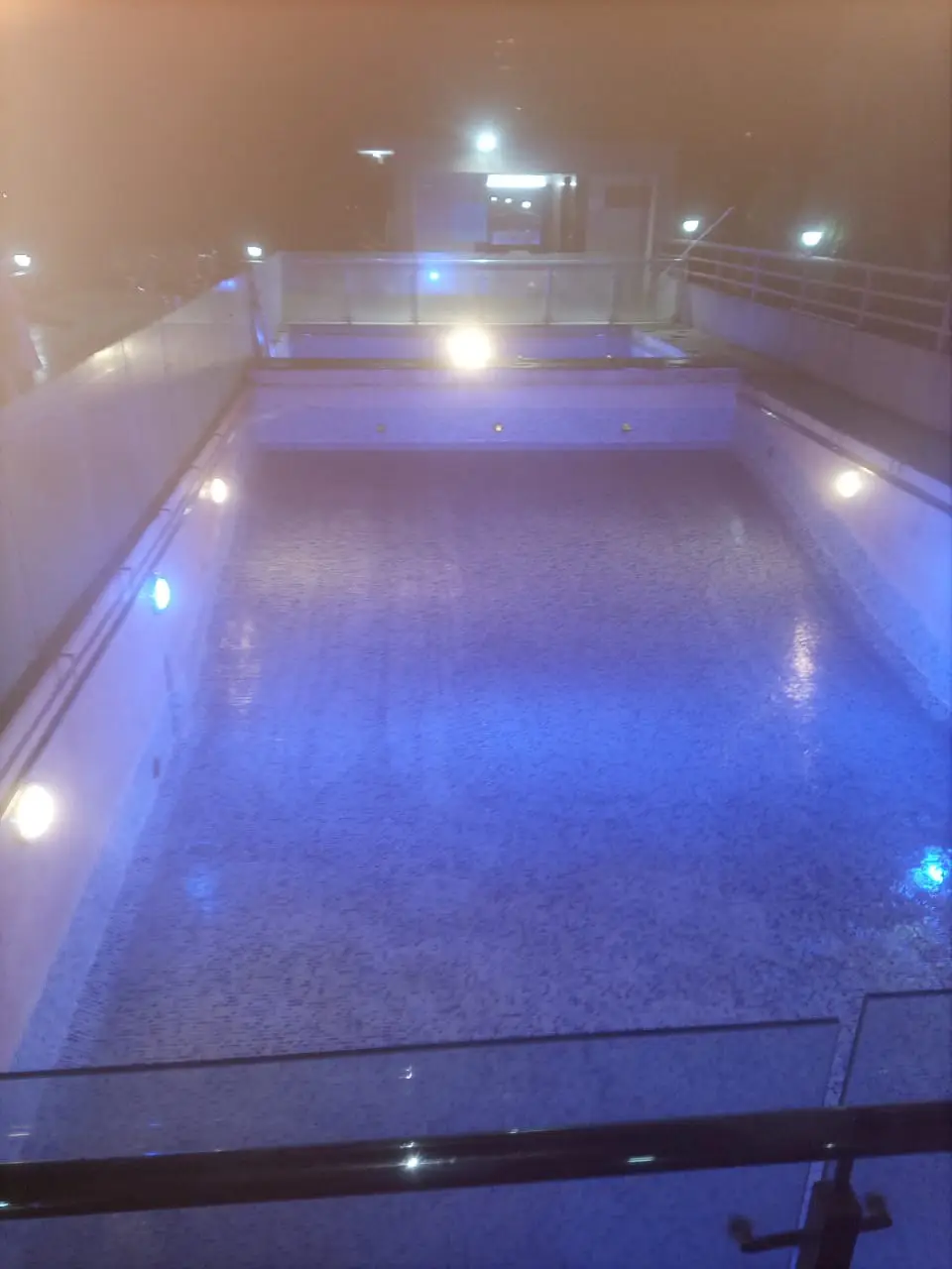 Rooftop swimming pool with evening lighting